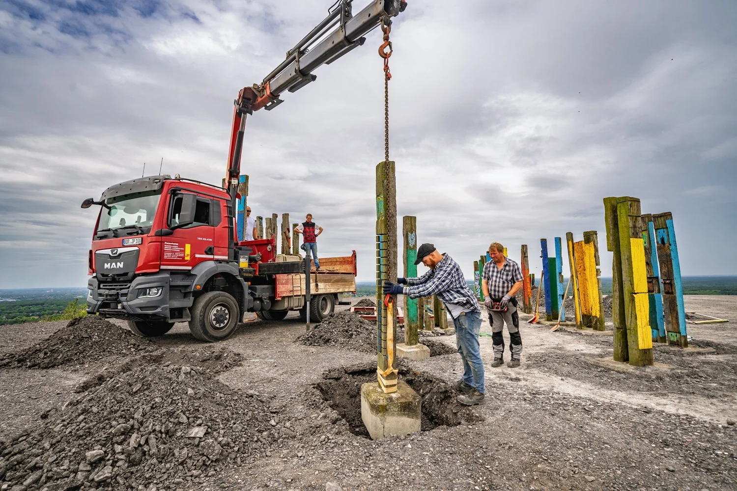 Halde Haniel, Letzte Arbeiten zur Neuaufstellung der restaurierten Totems von Augustín Ibarrola auf der Halde des Regionalverbands Ruhr, RVR. Die Totems wurden nach Schädigung durch Vandalismus von Ibarrola-Schüler Guido Hofmann instandgesetzt und unter der Bauleitung von Luis Guido Nielsen und dem Bauunternehmen Pennekamp aufgestellt. Wahrzeichen zurück: Totems prägen wieder die Halde Haniel in Bottrop
